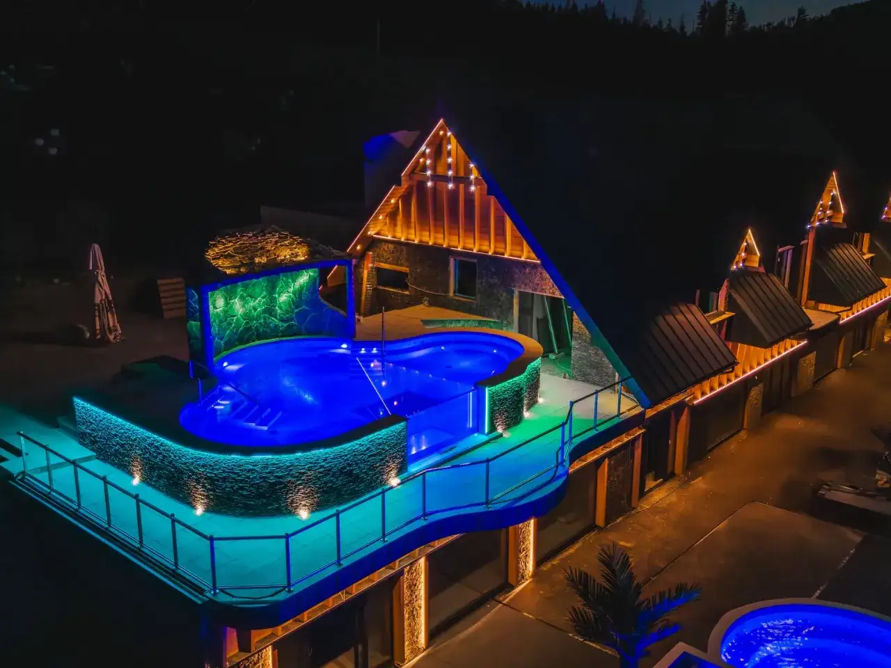 Nocny aquapark Stegna z podświetlanym basenem i architekturą góralską.