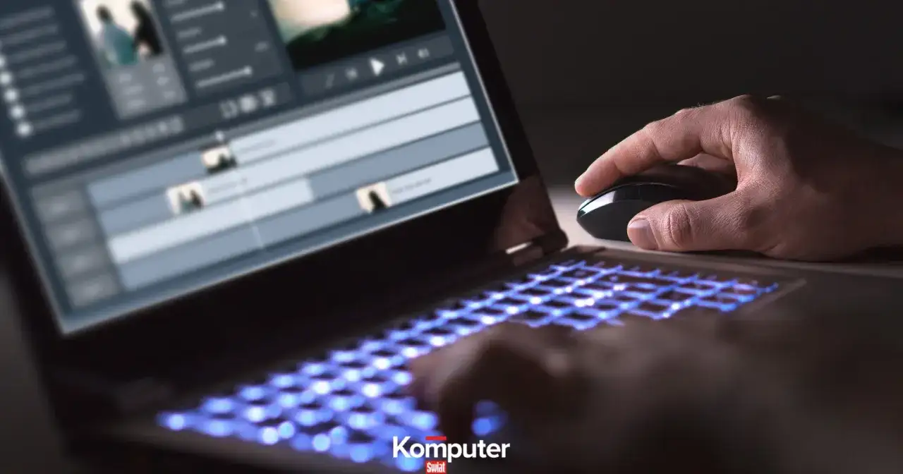 Dłoń steruje myszką przy laptopie z podświetlaną klawiaturą, edytując wideo w formacie HEVC.