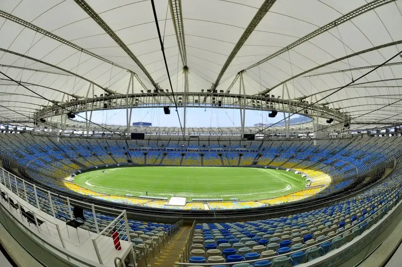 Pusta Maracana, z jej imponującą pojemnością, czeka na kibiców. Widok na zieloną murawę i żółto-niebieskie trybuny.