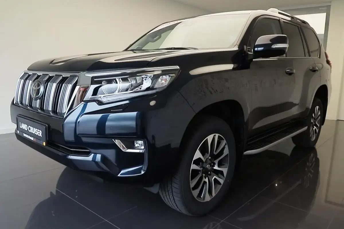 Ciemnogranatowy Land Cruiser Prado z chromowanym grillem i reflektorami LED, gotowy na każdą przygodę.