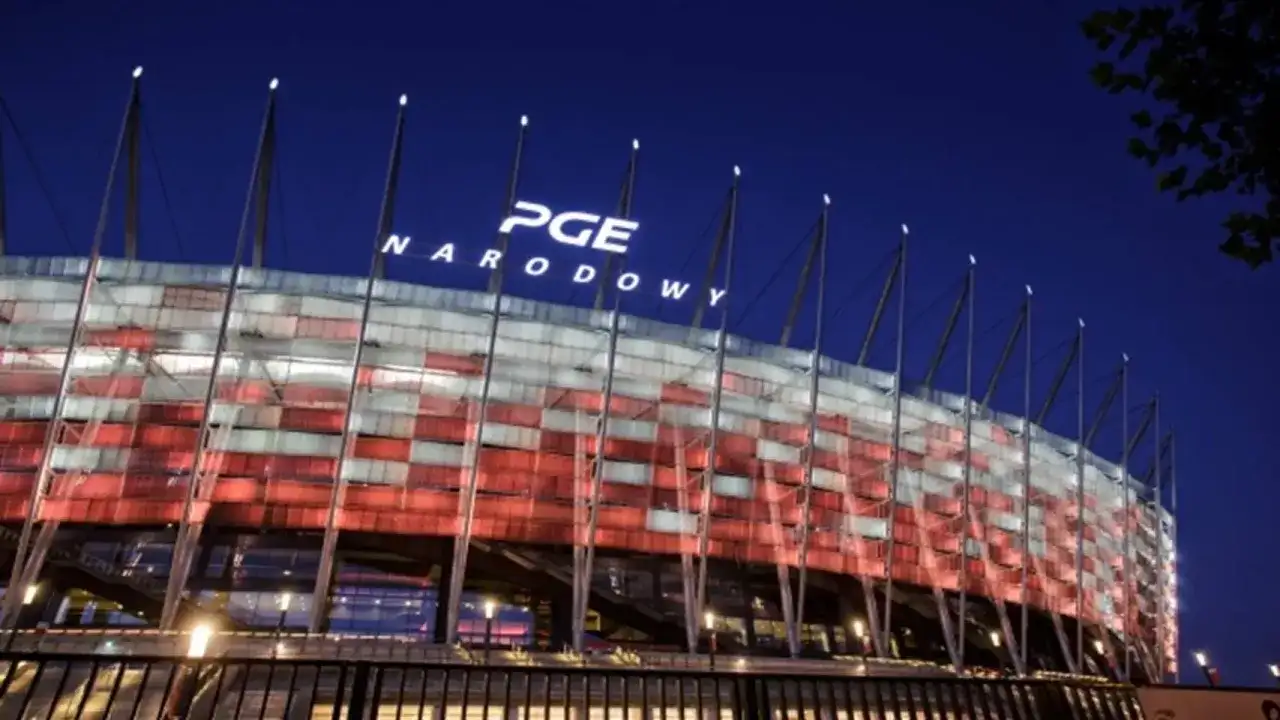 PGE Narodowy nocą, oświetlony w barwach narodowych. Imponująca pojemność stadionu robi wrażenie.