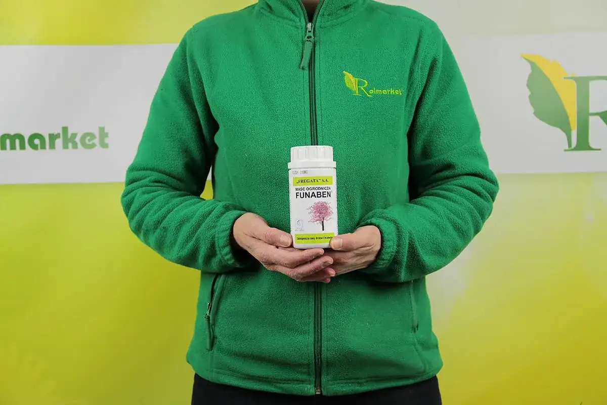 Osoba w zielonej bluzie trzyma maść ogrodniczą FUNABEN. Produkt przeznaczony do pielęgnacji drzew i krzewów.