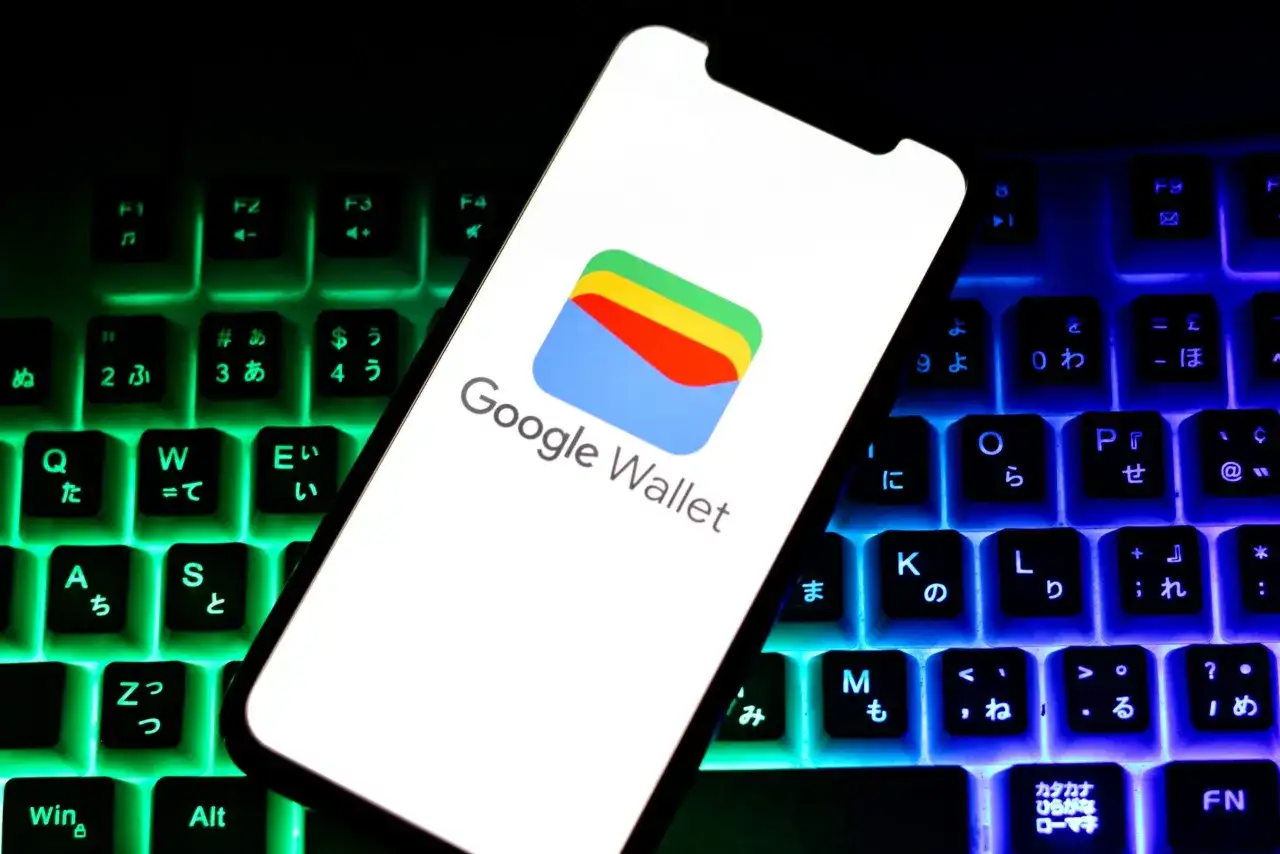 Smartfon z logo Google Wallet na tle podświetlanej klawiatury. Czy portfel Google jest bezpieczny? Odpowiedź znajdziesz w cyfrowym świecie.