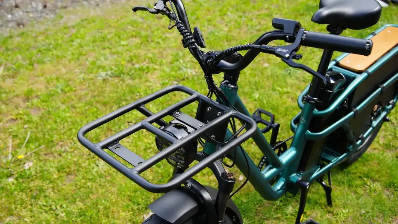 Zielony rower elektryczny dla seniora z dużą platformą bagażową z przodu i wygodnym siodełkiem. Idealny na zakupy i wycieczki.