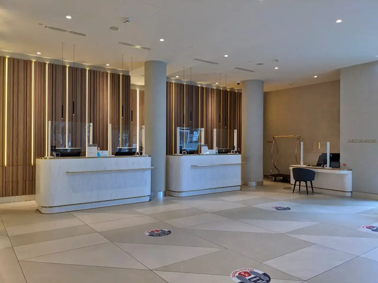 Eleganckie recepcje w Radisson Collection Hotel Warsaw, z nowoczesnym oświetleniem i marmurowymi blatami, zapraszają do komfortowego zameldowania.