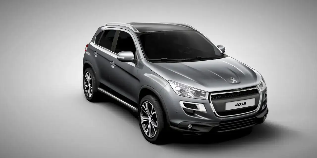 Szary crossover Peugeot 4008 z czarnym dachem i srebrnymi relingami, widok z przodu i z boku.