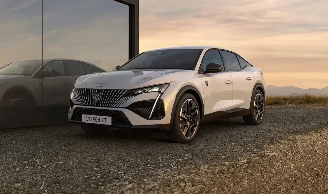Nowy Peugeot 408 w kolorze białym, z charakterystycznym grillem i nowoczesnymi światłami. Sprawdź jego atrakcyjną peugeot 408 cenę.