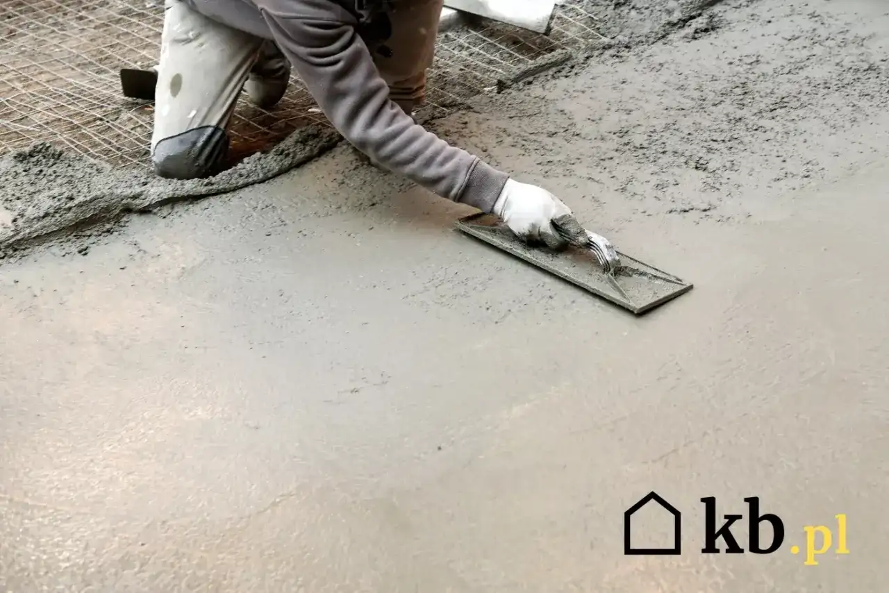 Ręczne zacieranie betonu kielnią, tworząc gładką powierzchnię. Praca na świeżym betonie.