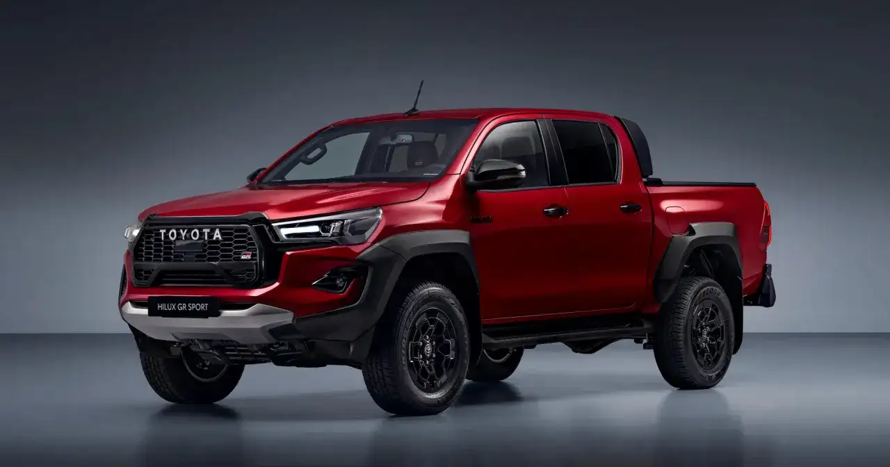 Czerwony Toyota Hilux GR Sport z czarnymi dodatkami i felgami, gotowy na każdą przygodę.