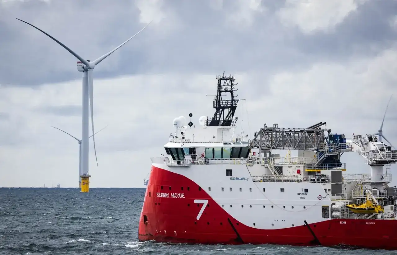 Statek Seaway Moxie przy pracy na budowie farmy wiatrowej na Bałtyku. W tle widać potężne turbiny wiatrowe.