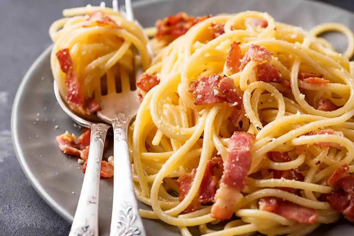 Spaghetti alla carbonara ricetta: un piatto cremoso con guanciale croccante e pecorino romano.
