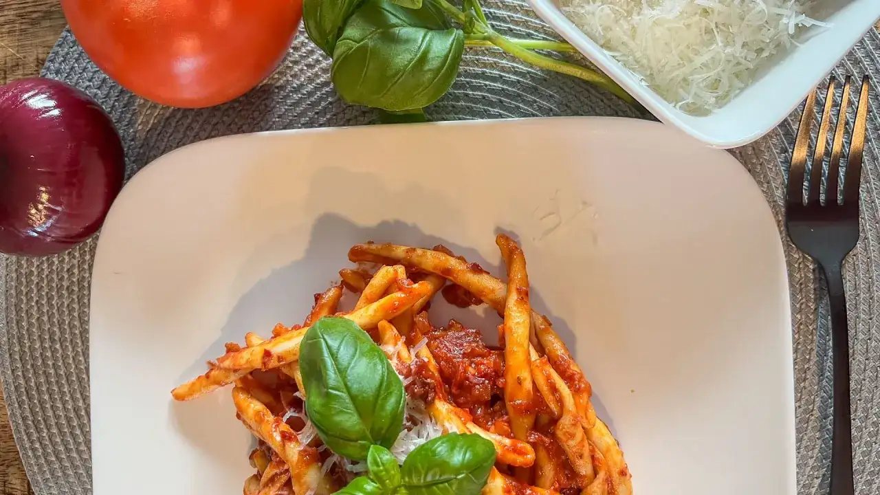 Makaron z sosem nduja, pomidorami, cebulą i bazylią. Pyszne danie, które wyjaśnia, nduja co to jest – pikantna, smarowna włoska kiełbasa.