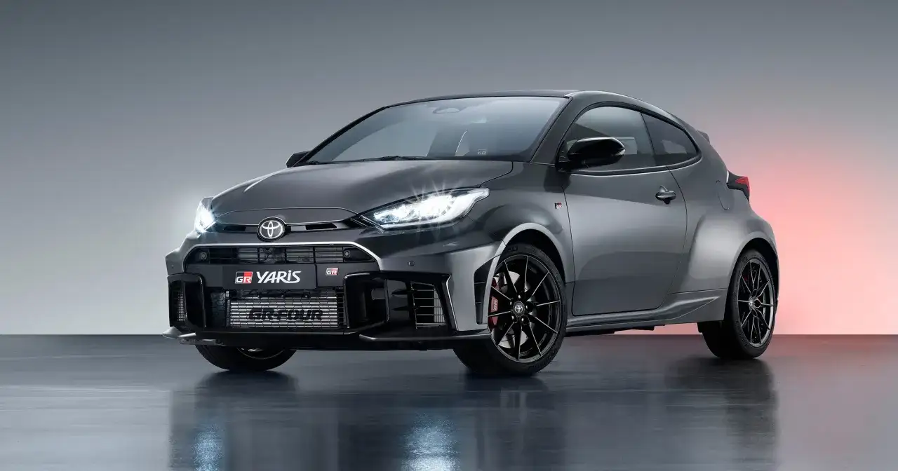 Szary Toyota GR Yaris z czarnymi felgami i czerwonymi zaciskami hamulcowymi, gotowy do akcji.