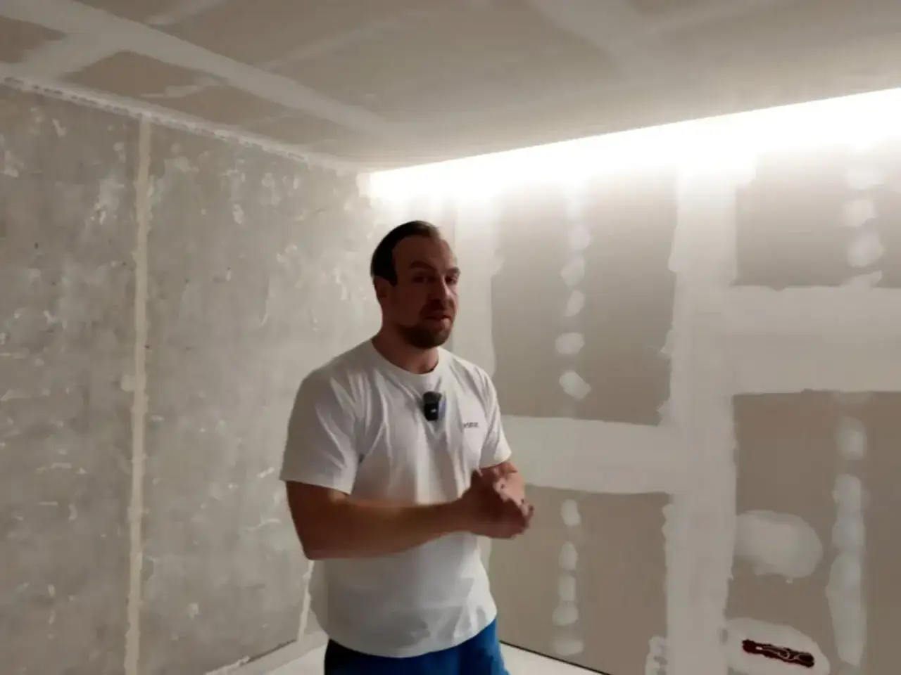 Mężczyzna prezentuje wnękę na led w suficie, która tworzy nowoczesne oświetlenie.