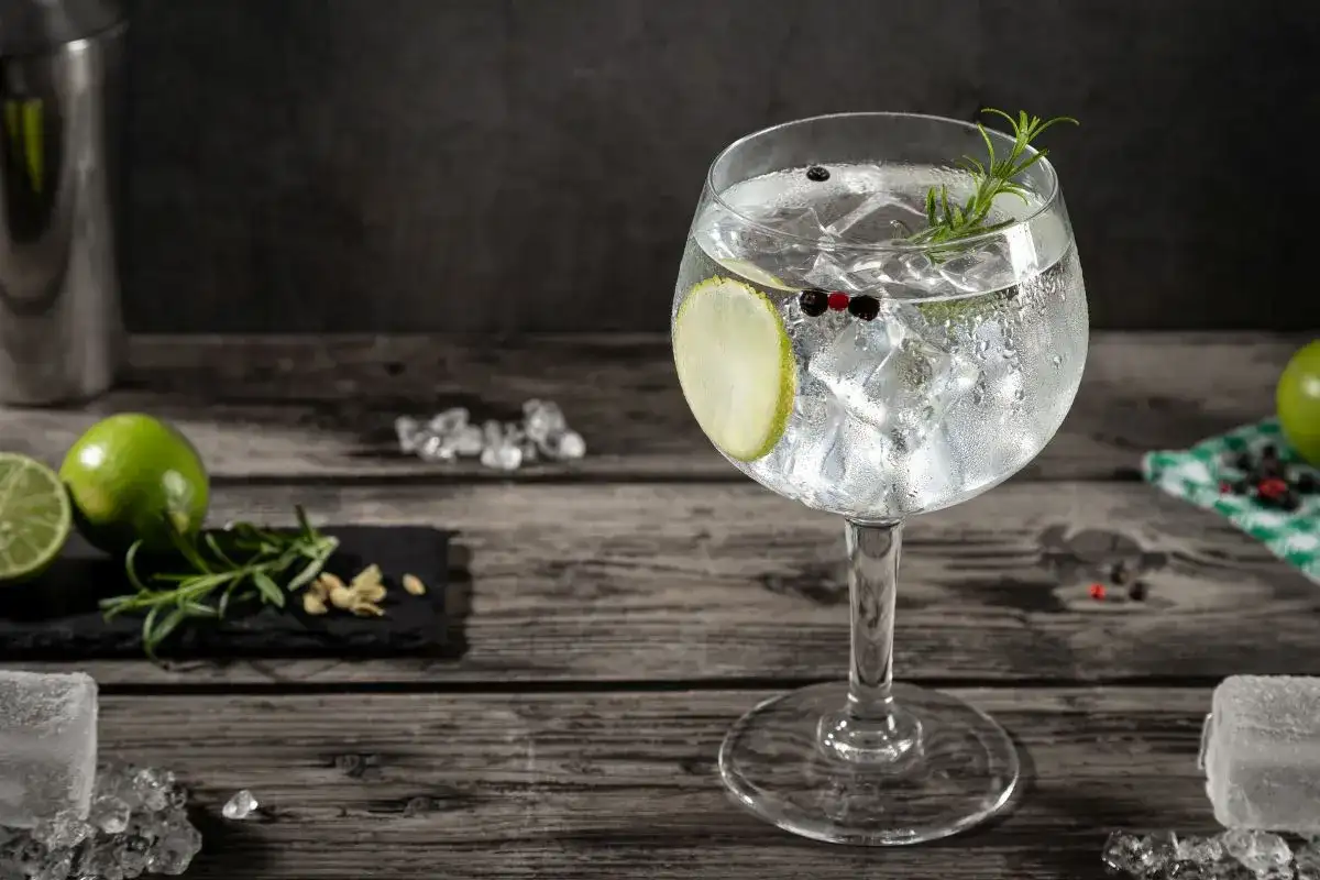 Orzeźwiający gin z tonikiem, udekorowany plasterkiem limonki, gałązką rozmarynu i ziarnami pieprzu. Idealny na letnie wieczory.