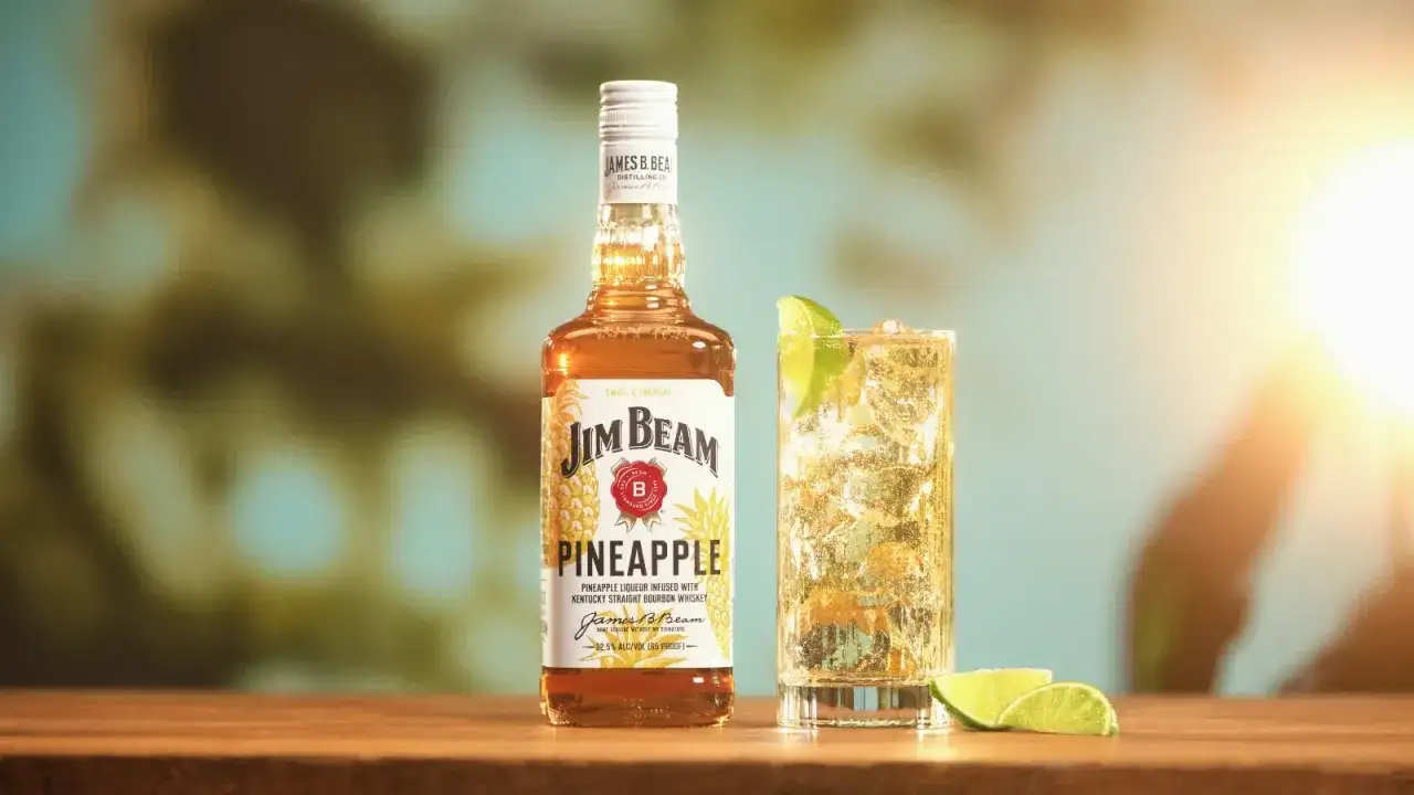 Butelka Jim Beam Pineapple i drink z limonką. Sprawdź, ile procent ma ten słodki, tropikalny likier.