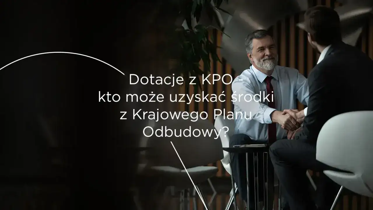 Dotacje z KPO – kto może uzyskać środki z Krajowego Planu Odbudowy? Dwóch mężczyzn w garniturach ściska sobie dłonie.