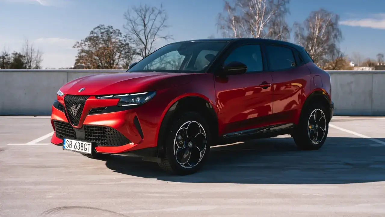 Czerwony Alfa Romeo Tonale na parkingu. Czy to superauto? Opinie są podzielone, ale wygląd robi wrażenie.