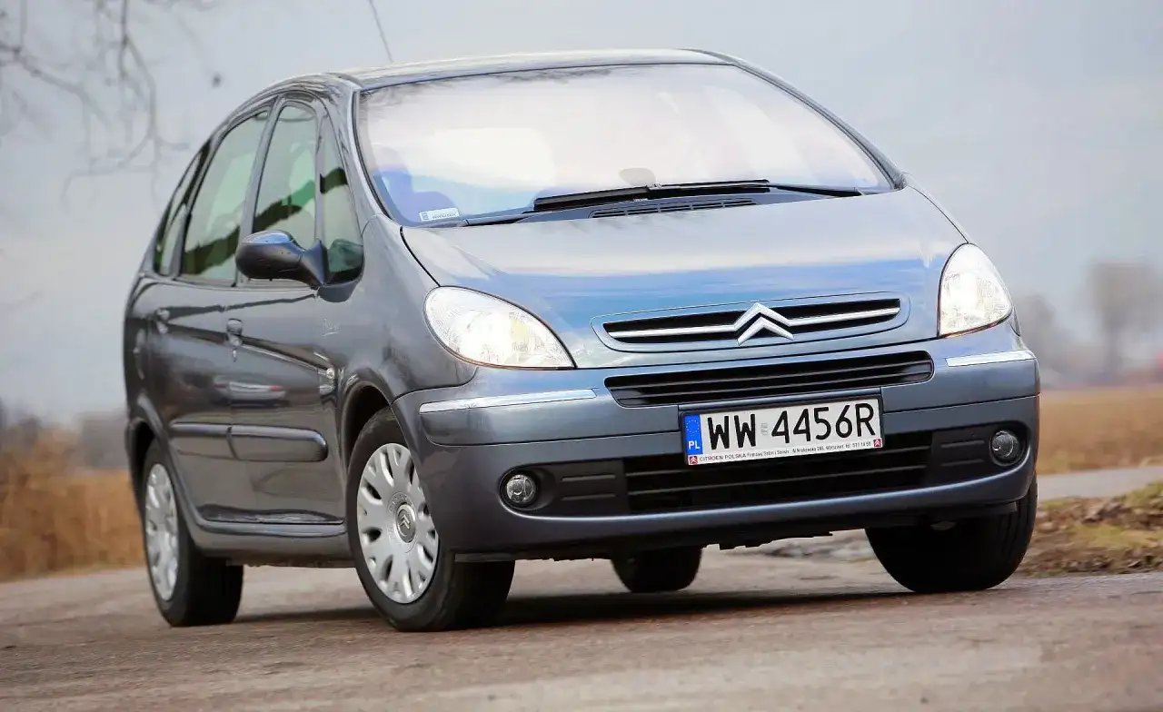 Szary Citroën Xsara Picasso z polskimi tablicami rejestracyjnymi WW 4456R jedzie po drodze.