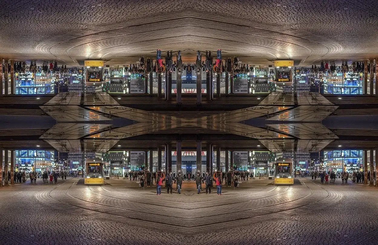 Nocne miasto z żółtym tramwajem i ludźmi. Kompozycja symetryczna tworzy surrealistyczny obraz.