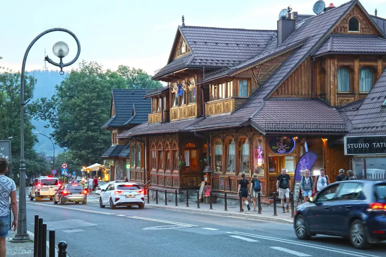 Spacer po Krupówkach, gdzie drewniana architektura przeplata się z ruchem ulicznym i turystami.