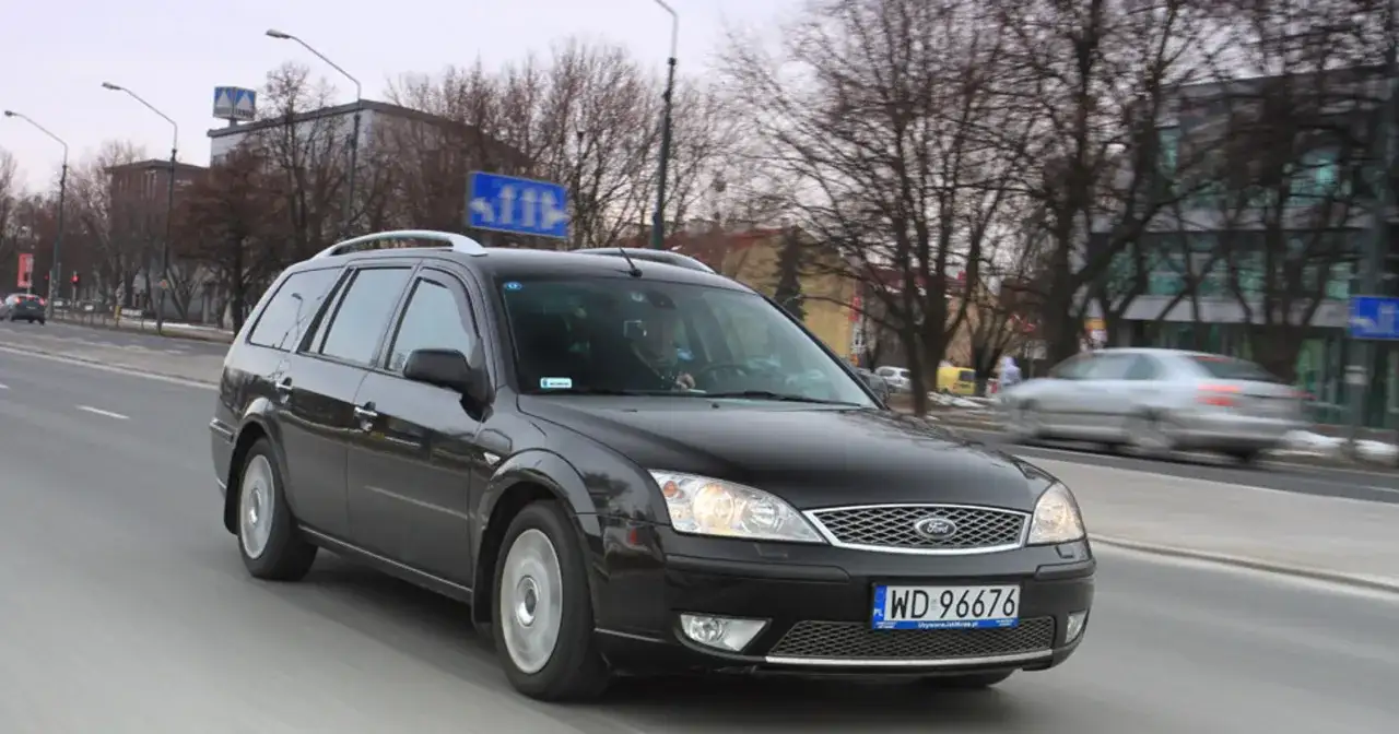 Czarny Ford Mondeo MK2 kombi jedzie ulicą.