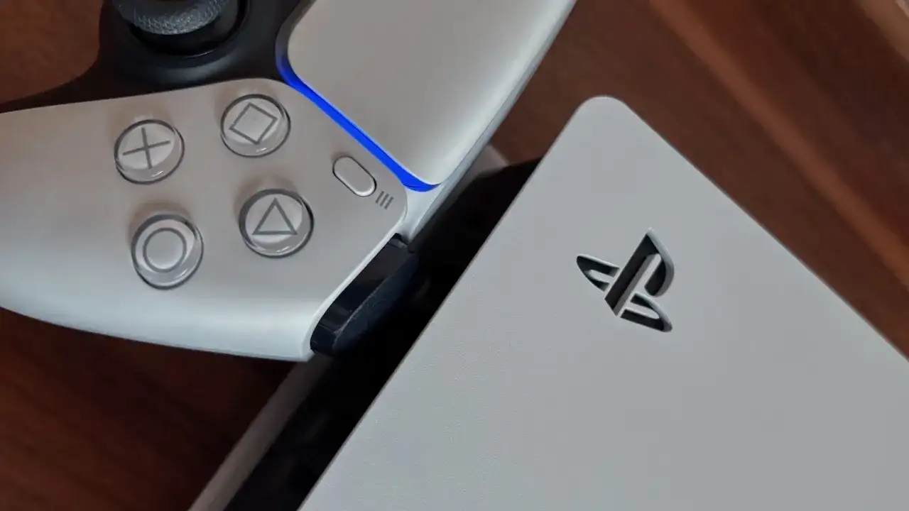 Zbliżenie na biały kontroler PlayStation 5 i konsolę z logo.