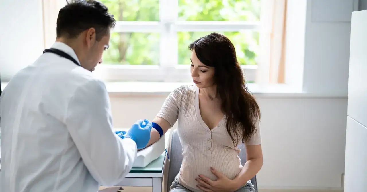 Lekarz pobiera krew od ciężarnej kobiety, badając podwyższone neutrofile w ciąży.