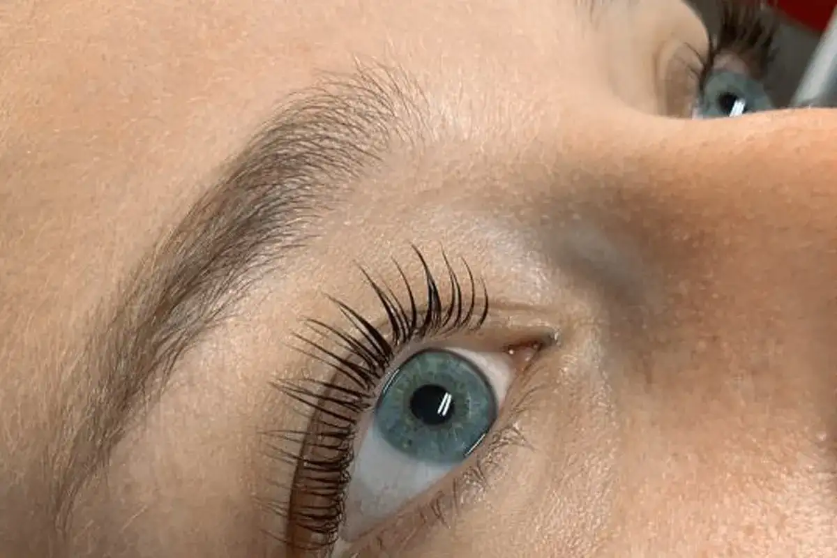Oko z błękitną tęczówką i pięknie podkręconymi rzęsami po zabiegu Yumi Lashes.