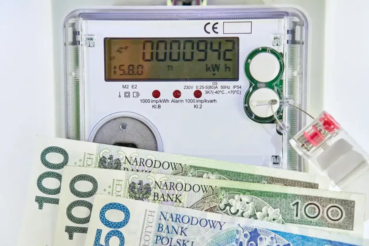 Licznik energii elektrycznej z polskimi banknotami. Zastanawiasz się, ile kosztuje 1 kWh?