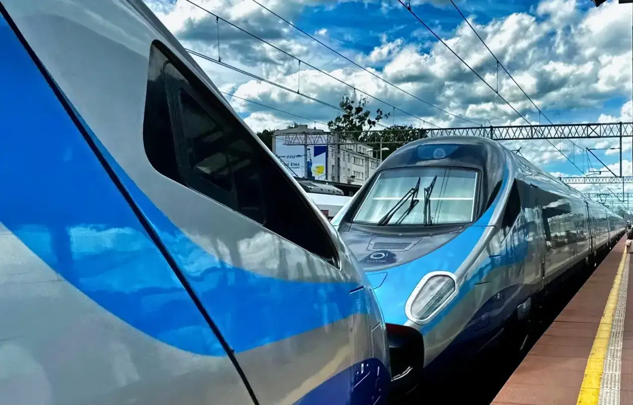 Dwa pociągi PKP Intercity stojące obok siebie na peronie. Jeden z nich to Pendolino, gotowe do podróży z Kołobrzegu do Krakowa Głównego.