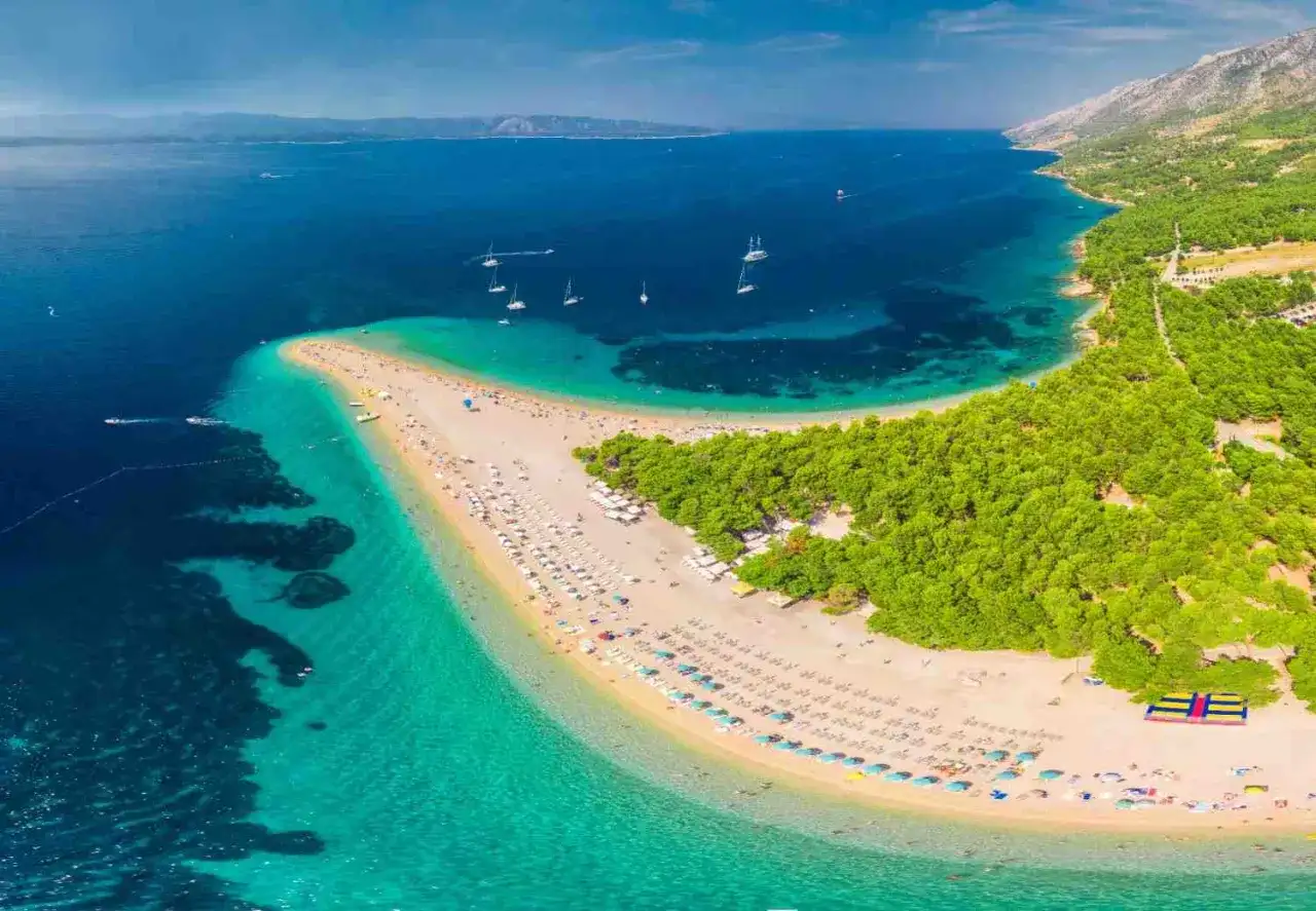 Zlatni Rat, jedna z najpiękniejszych plaż w Europie, z turkusową wodą i sosnowym lasem.