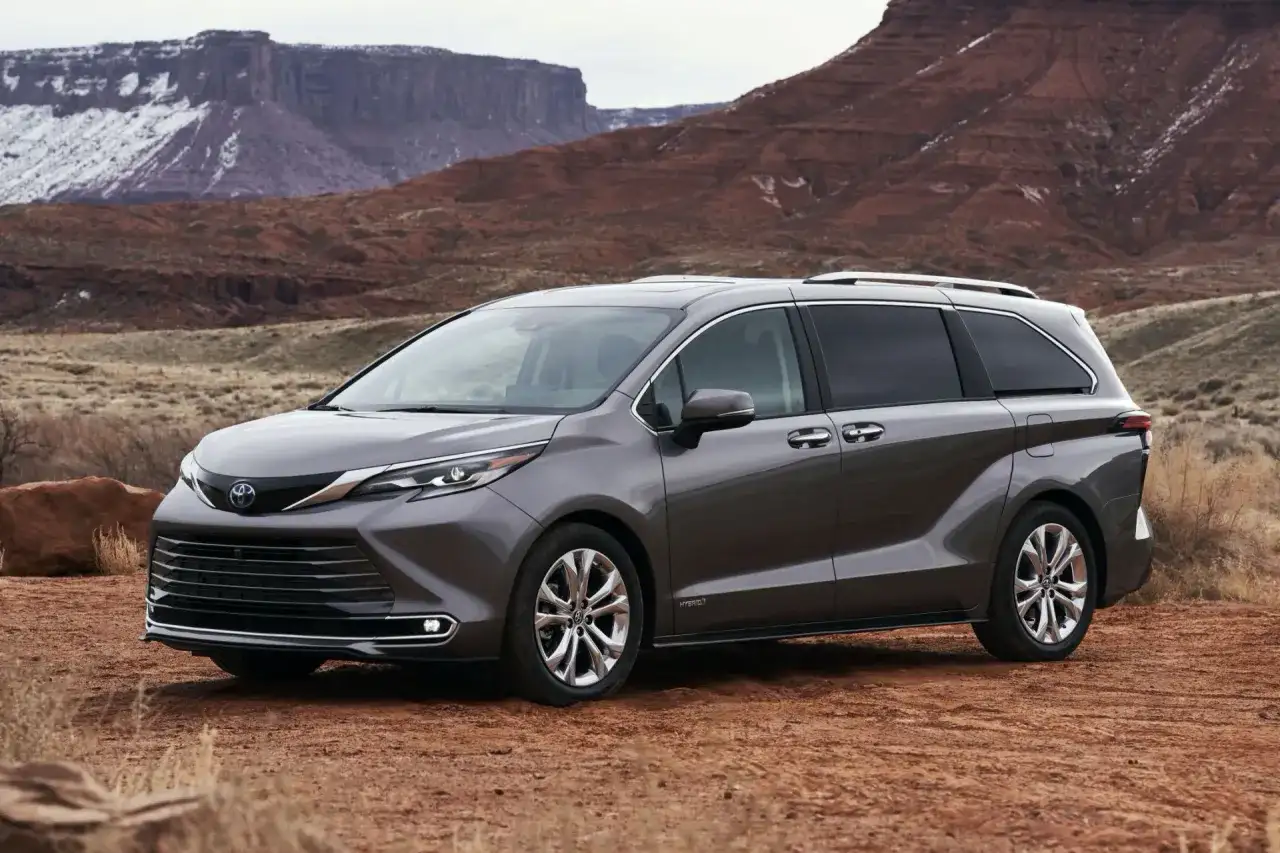 Szara Toyota Sienna na tle pustynnego krajobrazu z czerwonymi skałami.