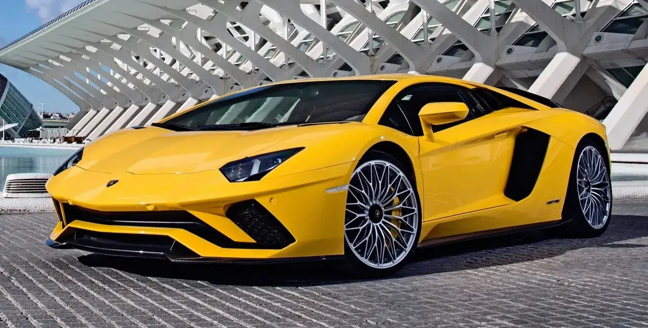 Żółty Lamborghini Aventador z futurystyczną architekturą w tle.