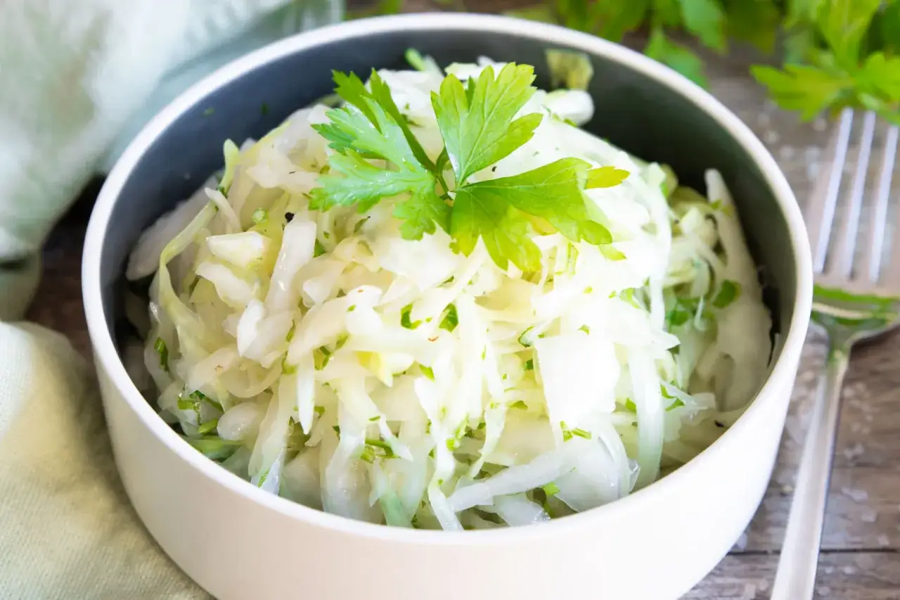 Frischer Krautsalat, perfekt zum krautsalat selber machen. Mit Petersilie garniert, serviert in einer Schüssel.