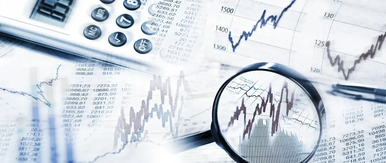 Analiza wykresów i tabel finansowych, kalkulator i lupa wskazują na analizę obligacji korporacyjnych emisji.