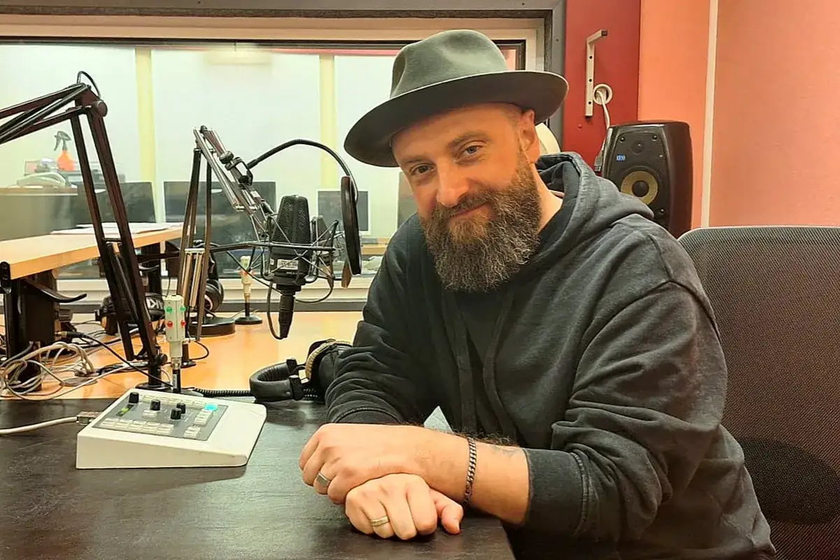 Łukasz Drapała w studio radiowym, gotowy na szalony bal dźwięków.