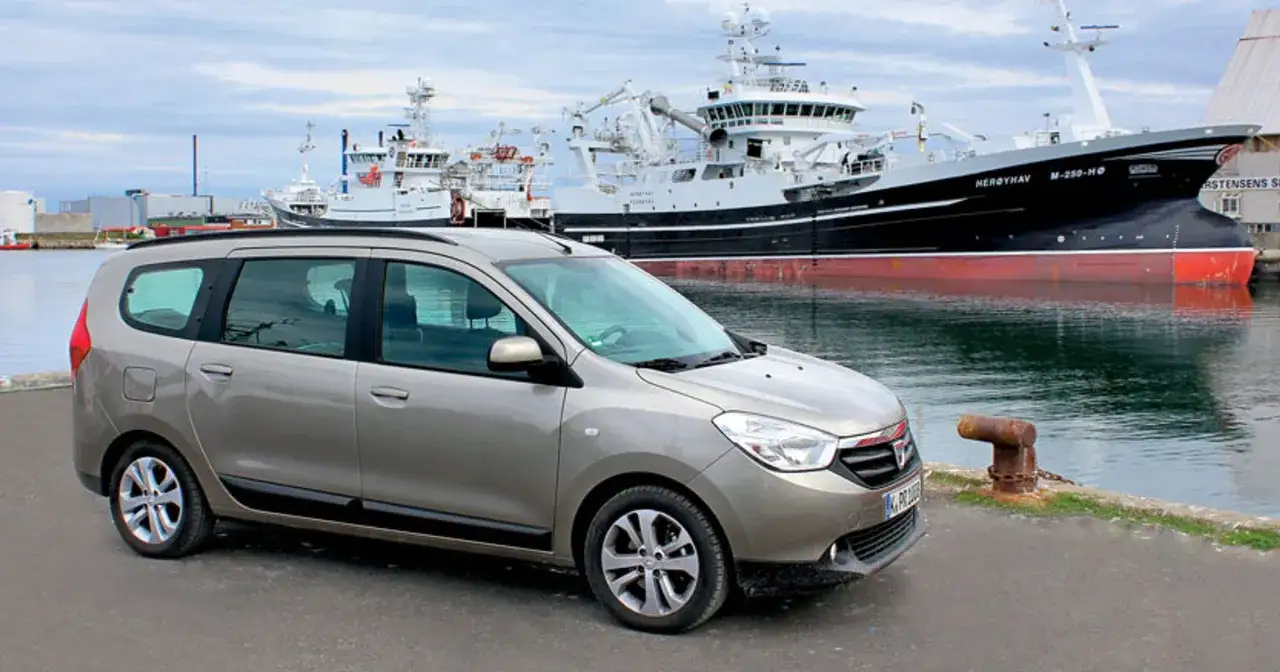 Brązowy Dacia Lodgy zaparkowany przy nabrzeżu, w tle wielkie statki rybackie.
