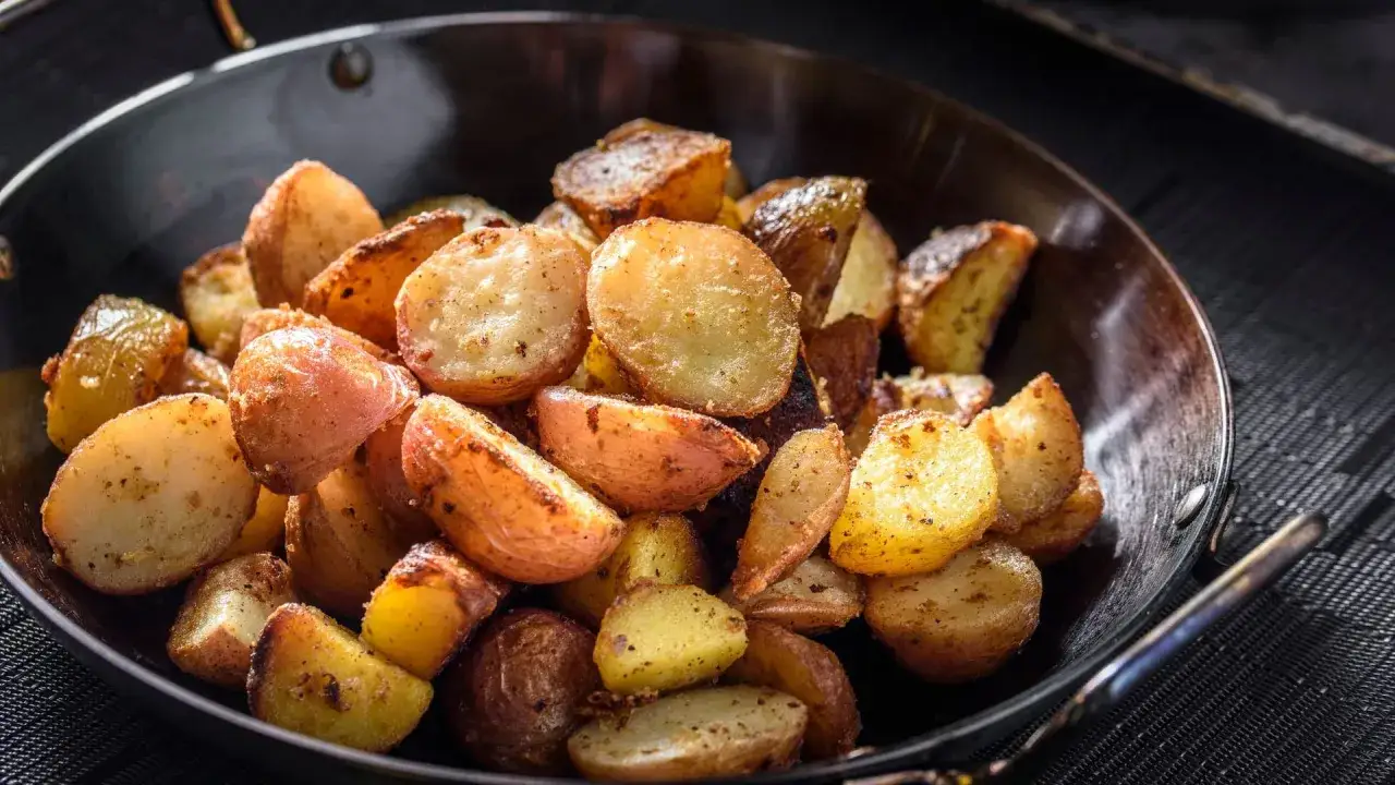 Goldbraune bratkartoffeln mit Ei, knusprig gebraten und würzig gewürzt, serviert in einer Pfanne.