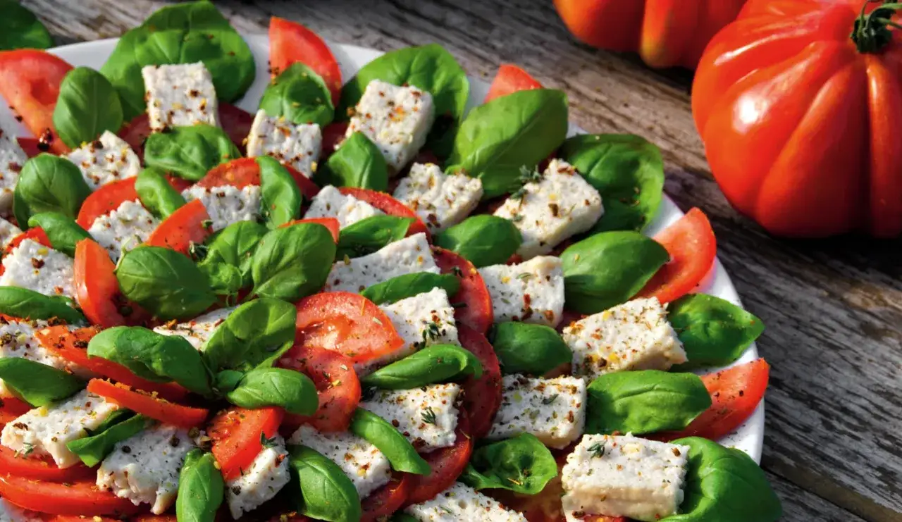 Frischer Tomaten-Mozzarella-Salat mit Basilikum, perfekt für ein veganes Party-Buffet.