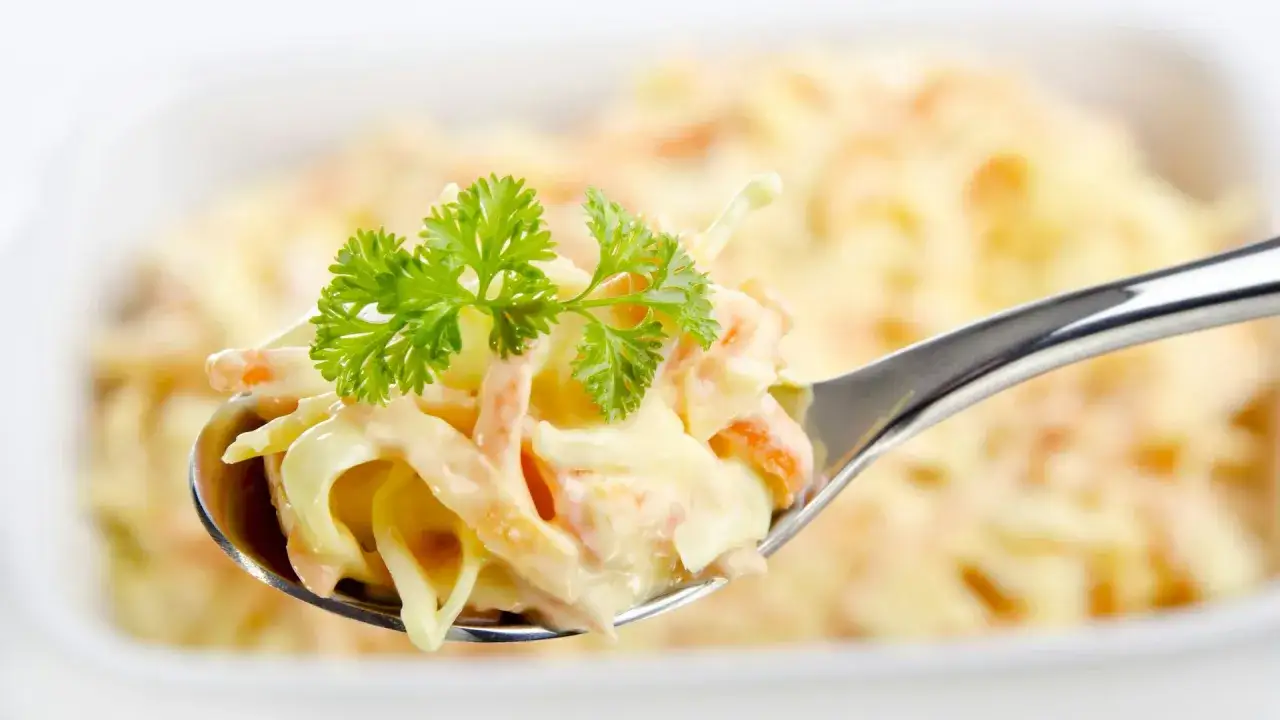 Ein Löffel cremiger Coleslaw Salat, garniert mit Petersilie. Perfekt für ein einfaches coleslaw salat rezept.