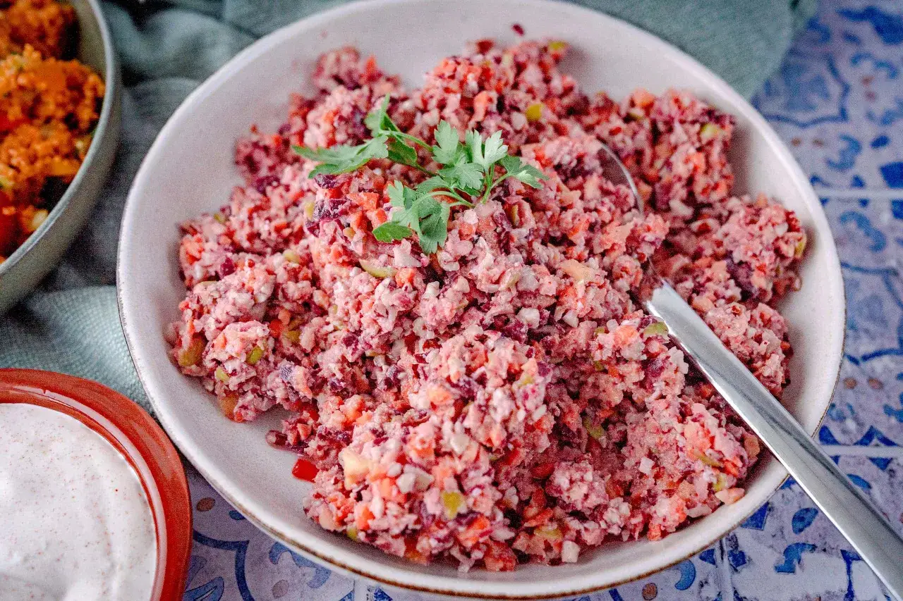 Bunter Karottensalat, frisch zubereitet im Thermomix, garniert mit Petersilie. Daneben eine Schale mit cremiger Sauce.