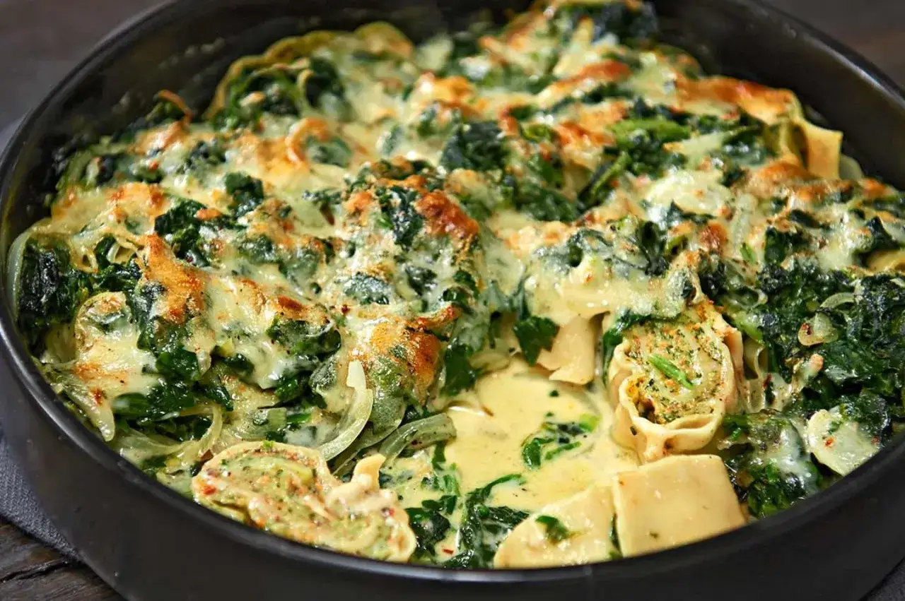 Herzhafter Maultaschen Auflauf mit Spinat und cremiger Käsesauce, goldbraun überbacken.