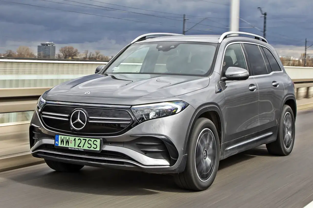 Szary Mercedes EQB jedzie po moście.