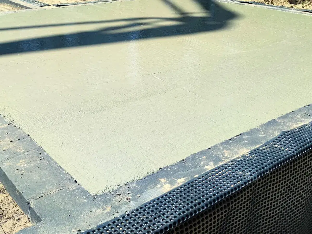 Świeży beton na podbudowie. Czy pod chudziaka daje się folię? Tu widać drenaż i izolację.
