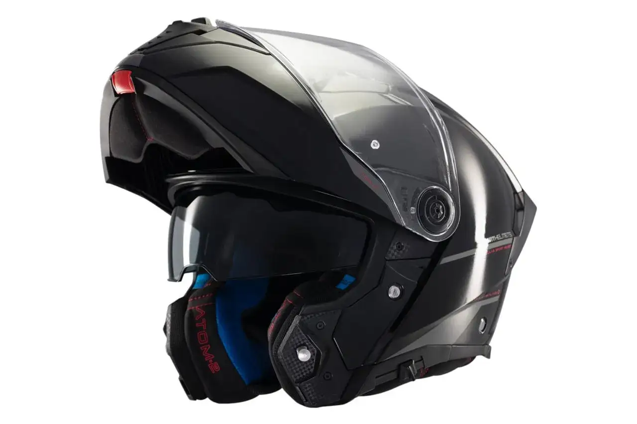 Czarny kask motocyklowy szczękowy z podnoszoną szybką i przyciemnianą szybką wewnętrzną.