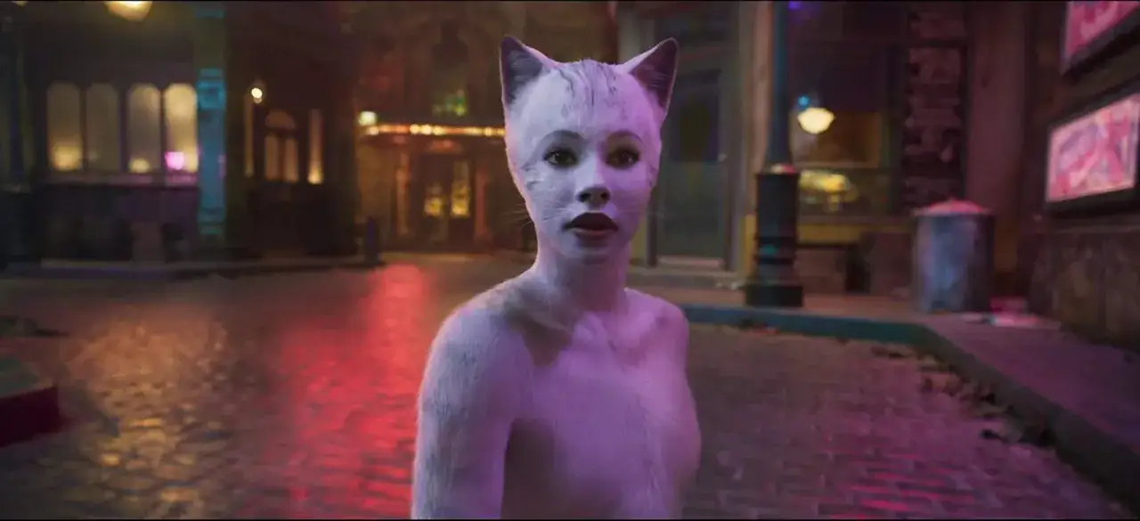 Kobieta z kocimi uszami i futrem, jak z obsady musicalu "Koty", stoi na nocnej ulicy.