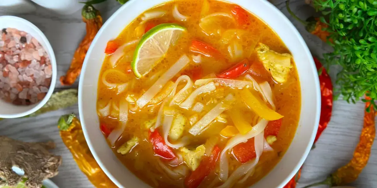 Aromatyczna zupa z makaronem ryżowym, z kawałkami kurczaka, papryki i plasterkiem limonki.
