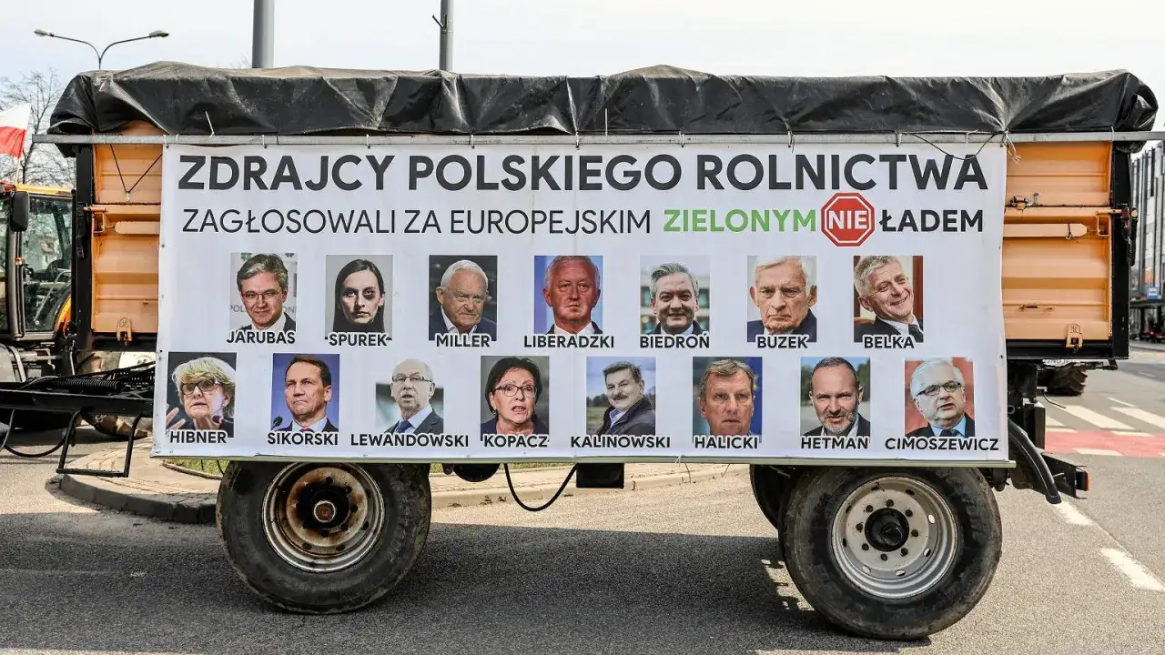 Plakat na przyczepie z portretami europosłów i napisem "Zdrajcy polskiego rolnictwa".