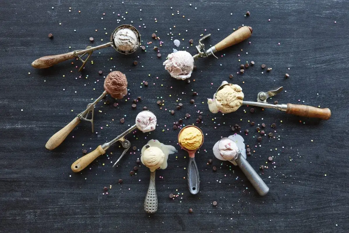 Verschiedene Eissorten in Eislöffeln, bereit zum Servieren. Perfekt, um eis selber machen zu wollen! Bunt bestreut mit Schokostückchen und Streuseln.